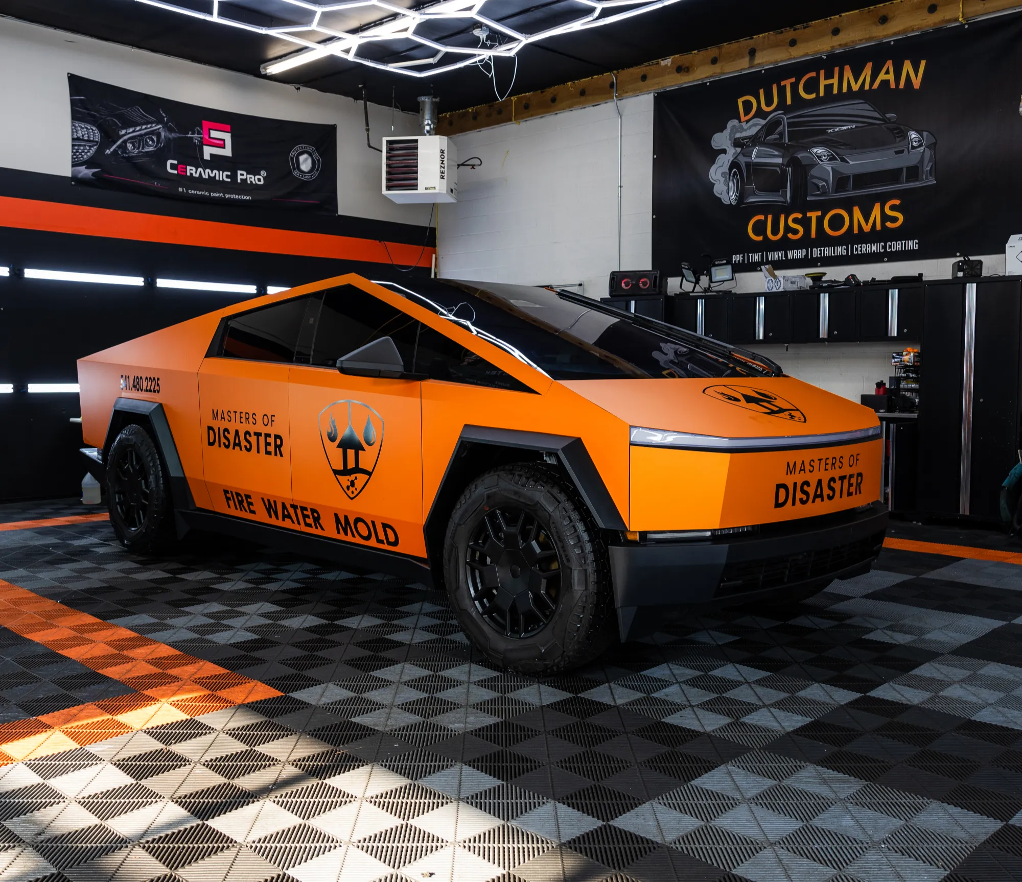 Tesla Cybertruck in an orange Masters of Disaster commercial wrap