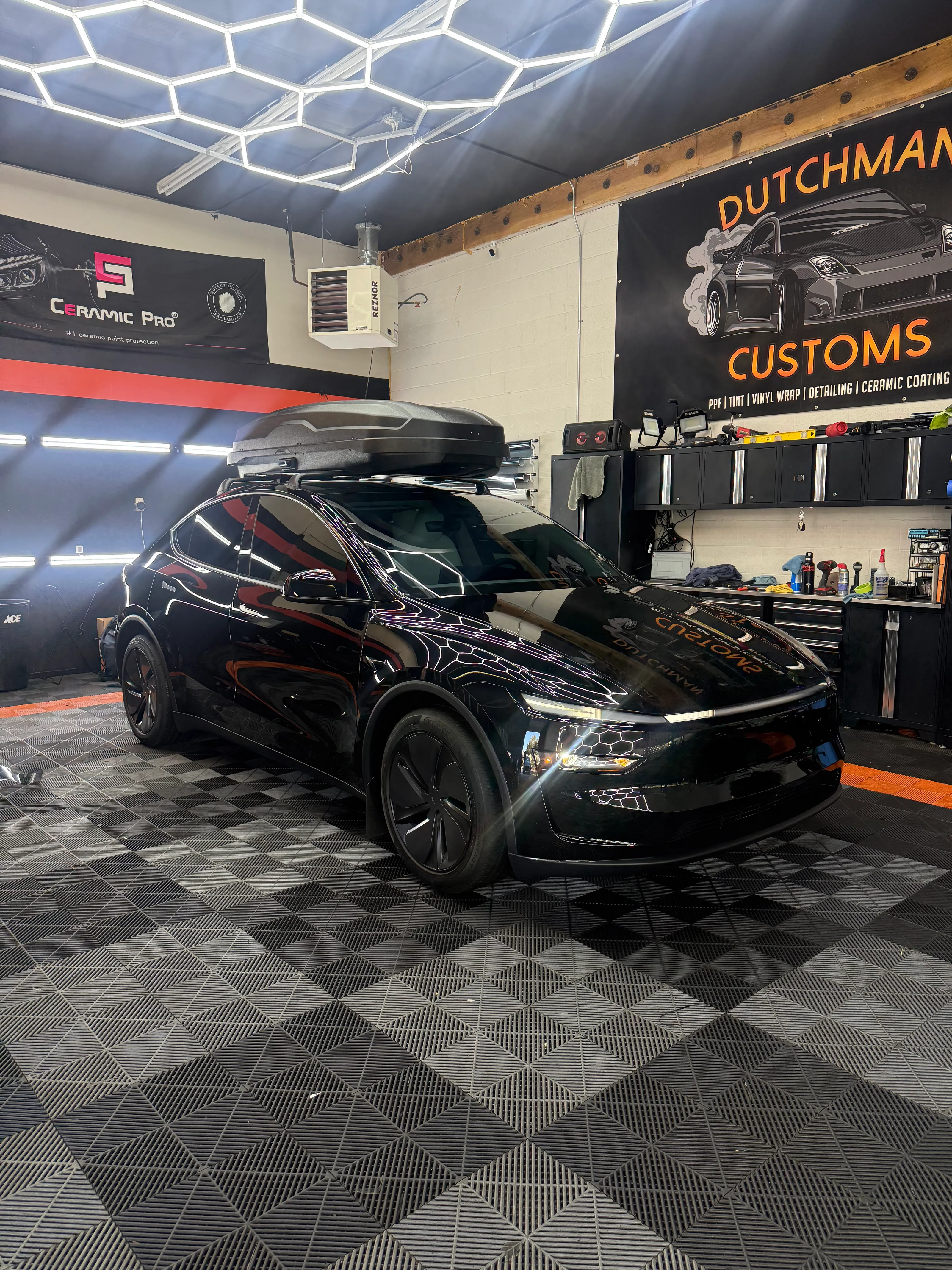 Black Tesla Model X with roof box in the bay